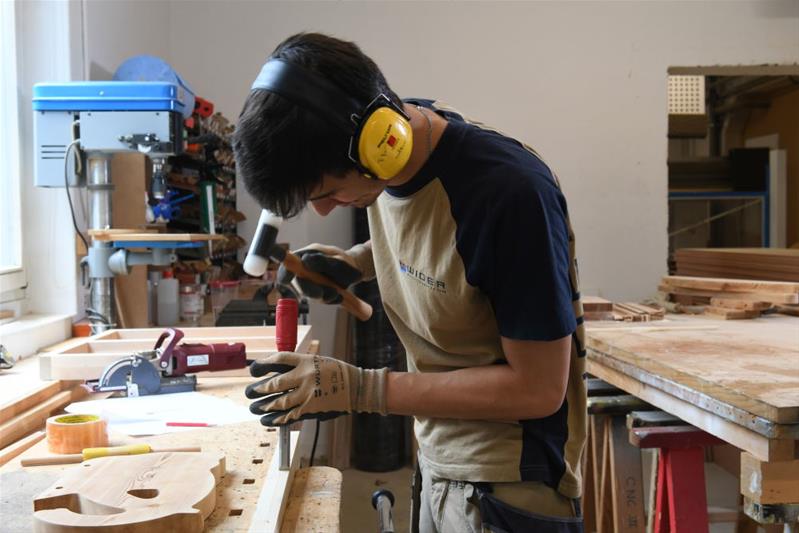 Un uomo lavora un pezzo di legno