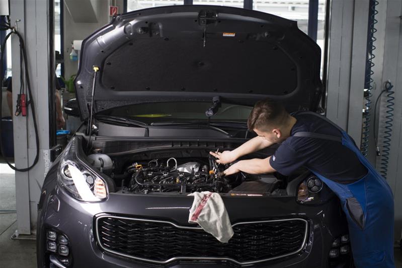 Un tecnico aggiusta il motore di un'automobile